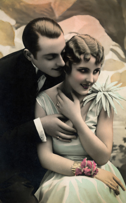 Émile et Julienne – Le bonheur partagé Dans cette carte postale romantique, Émile enlace Julienne. La présence d'un bouquet et la délicatesse des gestes traduisent la douceur des romances de l'entre-deux-guerres.