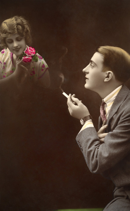 Émile et l'Absente rêvée – Le souvenir d'une rose Dans cette carte postale de la Belle Époque, Emile contemple l’apparition d’une femme dans un halo de fumée. Le photomontage donne ainsi une présence presque réelle à celle qui flotte littéralement devant lui.