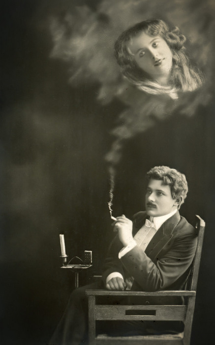L'Absente rêvée d'Ernest – Scène 2 Dans cette carte postale, Ernest pense à la femme qu’il aime et le visage de celle-ci se forme peu à peu dans la fumée de sa cigarette. Ce photomontage témoigne de l’étonnante virtuosité technique des photographes de l’époque.