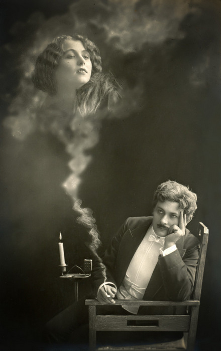 L'Absente rêvée d'Ernest – Scène 5 Dans cette carte postale, Ernest pensif songe à la femme qu'il aime. Celle-ci apparaît dans la fumée de sa cigarette.
