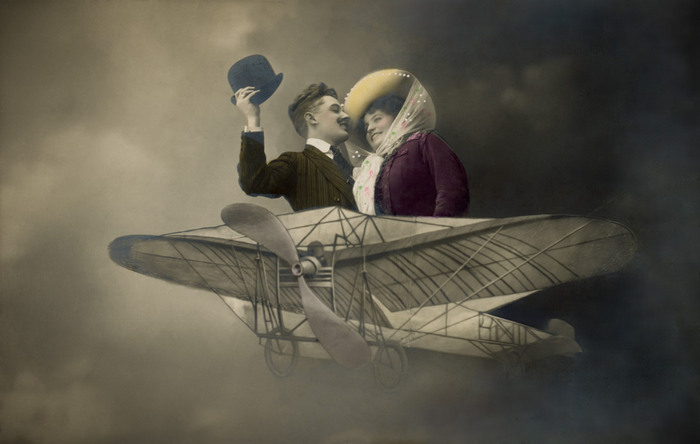 Ernestine et Clotaire – Cap vers les nuages Ernestine et Clotaire prennent place dans un aéroplane. Cette carte postale photographique de la Belle Époque donne vie au rêve d’aviation.