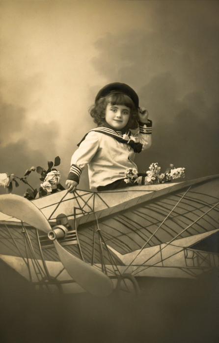 Harold – Petit aviateur Harold prend place dans un aéroplane reconstitué en studio. Cette carte postale photographique témoigne de la fascination pour l’aviation et des rêves de voyage qui nourrissaient l’imaginaire de la Belle Époque.
