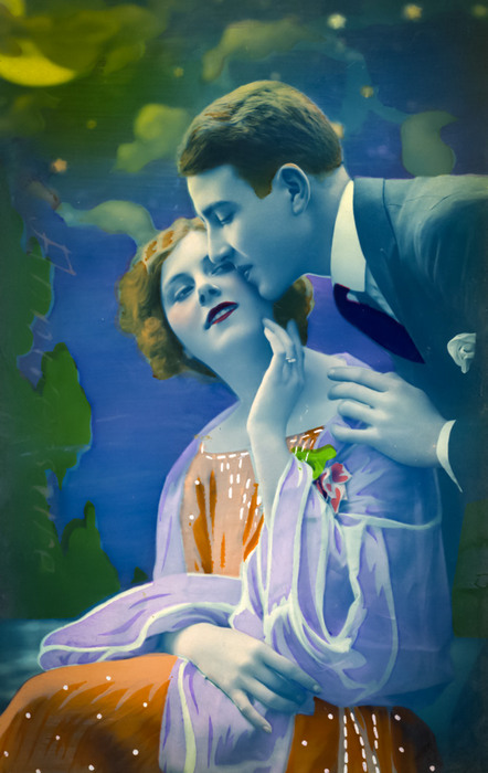 Jeanne et Lucien sous le ciel étoilé Jeanne Helbling s'abandonne dans les bras de Lucien au cœur d’un décor nocturne aux teintes bleutées. Cette carte postale photographique colorisée évoque les scènes romantiques des Années folles.