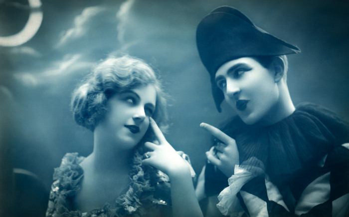 Colombine et Arlequin – « Mon œil ! » Dans cette carte postale ancienne inspirée de la commedia dell'arte, Jeanne Helbling, déguisée en Colombine, regarde Arlequin avec malice.