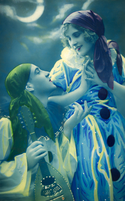 Jeanne et Lucien – Regards amoureux Colombine pose délicatement sa main sur le visage de Pierrot, sous un croissant de lune. Cette carte postale ancienne, colorisée dans les ateliers d'impression, témoigne du romantisme des Années folles.