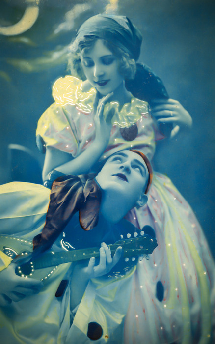 Jeanne et Lucien – La sérénade au clair de lune Pierrot joue de la mandoline tandis que Colombine se penche tendrement vers lui. Cette carte postale ancienne a été colorisée dans les années 20.