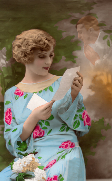Jeanne lisant – Le souvenir amoureux vers 1920 Dans cette carte postale des années 1920, une jeune femme lit une lettre tandis que son amoureux apparaît en transparence derrière elle. Le subtil jeu de superposition crée une étonnante apparition, témoignant de la virtuosité des photomontages de l’époque.