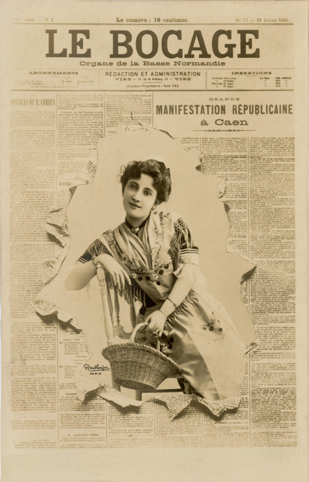 Le Bocage – L'art du journal déchiré vers 1900 Dans cette carte postale ancienne, une jeune femme, assise avec son panier, semble surgir des pages déchirées du Bocage. Le jeu de découpe crée une étonnante illusion de profondeur et donne l’impression que son portrait traverse la page du journal.