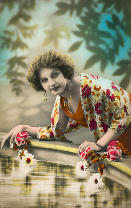 Rosalie – Le châle aux motifs fleuris Au bord d'un bassin, Rosalie est vêtue d'un châle aux motifs floraux aux couleurs éclatantes. Cette photographie ancienne de la Belle Époque met en valeur l'élégance des étoffes et des broderies du début du XXᵉ siècle.