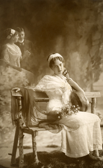 Le Songe d'Angèle – Photomontage romantique vers 1900 Dans cette carte postale de la Belle Époque, Angèle songe à une rencontre amoureuse. Le photomontage fait apparaître derrière elle l’image d’un couple, une scène née de son imagination.