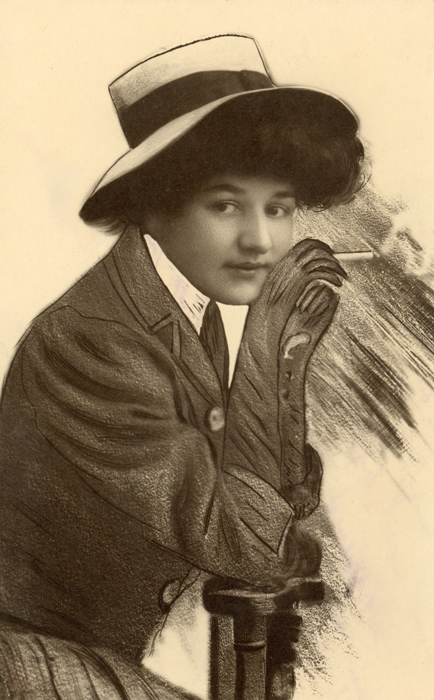 Colette prend la pose avec élégance Dans ce portrait de la Belle Époque, Colette pose appuyée sur une chaise, son visage photographié se détachant sur un ensemble entièrement dessiné. Le dessin restitue ses vêtements, son chapeau et le décor avec un travail particulièrement minutieux.