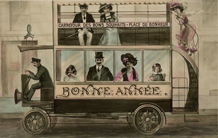 Le bus des bons souhaits Dans cette carte postale de la Belle Époque, des portraits photographiques sont intégrés à un autobus illustré portant l’inscription « Carrefour des bons souhaits – Place du Bonheur ». Cette composition originale mêle photographie, dessin et peinture pour adresser des vœux de bonne année avec fantaisie.