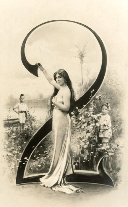 Chiffre illustré 2 – Belle Époque Dans cette carte postale de la Belle Époque, une jeune femme et deux enfants prennent place autour du chiffre 2, au cœur d’un décor champêtre. Le chiffre s’intègre naturellement au paysage.