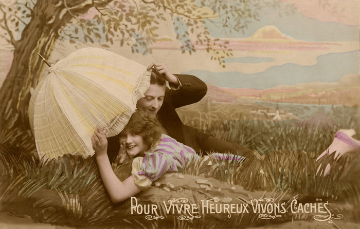 Andrée et Marcel | Pour vivre heureux Andrée et Marcel se cachent sous une ombrelle dans un paysage champêtre composé en studio. Le décor peint, la photographie et la mise en couleur se mêlent pour créer une scène romantique et pleine de fantaisie.