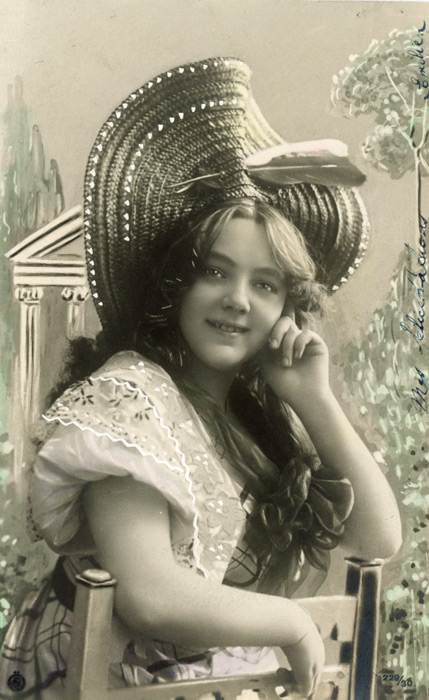 Le jardin de Célestine | Décor peint Dans ce portrait photographique de la Belle Époque, Célestine pose devant un décor peint évoquant un jardin romantique. Son grand chapeau de paille et sa pose décontractée renforcent l’atmosphère champêtre de cette composition.