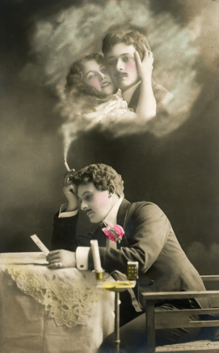 L'Absente rêvée d'Ernest – Scène 8 Dans cette carte postale de la Belle Époque, Ernest regarde la photographie de la femme qu’il aime, tandis que leur étreinte apparaît dans la fumée de sa cigarette.
