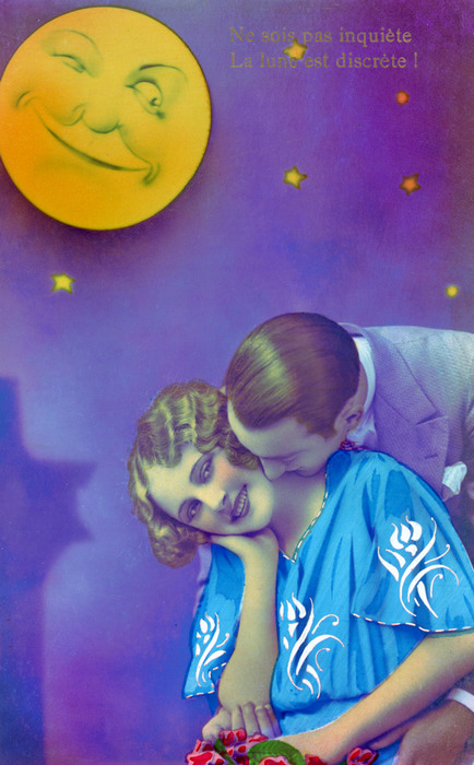 Liliane et Émile – Confidence sous la lune Liliane, la tête délicatement inclinée, écoute Émile qui se penche vers elle. La colorisation de cette carte postale ancienne est d'origine.