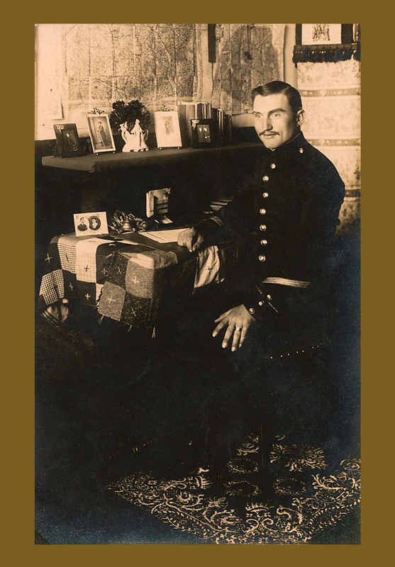 Photographie de Clotaire Lefort dans son bureau vers 1910, en uniforme de sous-officier, entouré de cartes et de photographies.