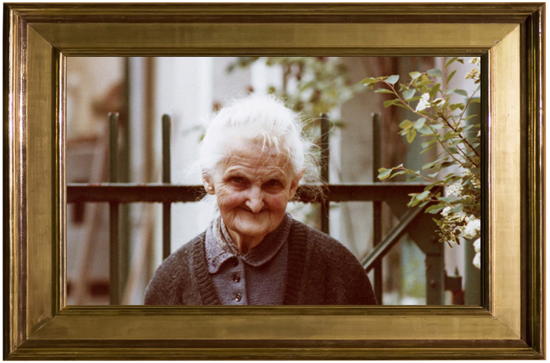 Portrait d'Ernestine Lefort, souriante, photographiée dans le jardin familial, à Argent-sur-Sauldre.
